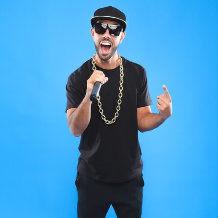 MC Grammar singing into a microphone pointing at himself