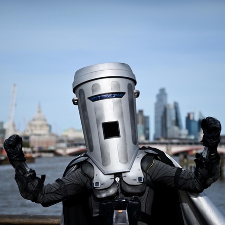 A photo of Count Binface - he has his fists raised up. In the Background is the London city skyline.