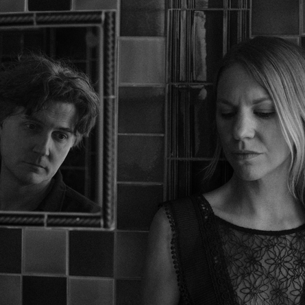 A black and white photo of the music duo Maven Grace. They are both looking sombre.