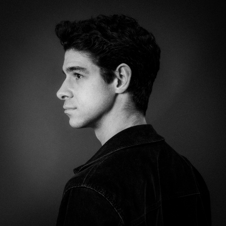 A black and white photo of the artist Conner McLeod, it' a side profile photo.